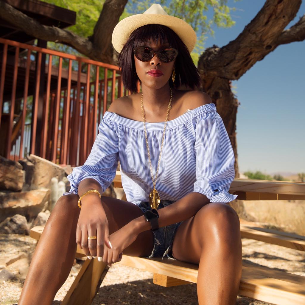 Model Wearing Dalasini Bulawayo Gold Shield Pendant Necklace and Earrings Isiro Gold Vertebrae Bracelets and Rings